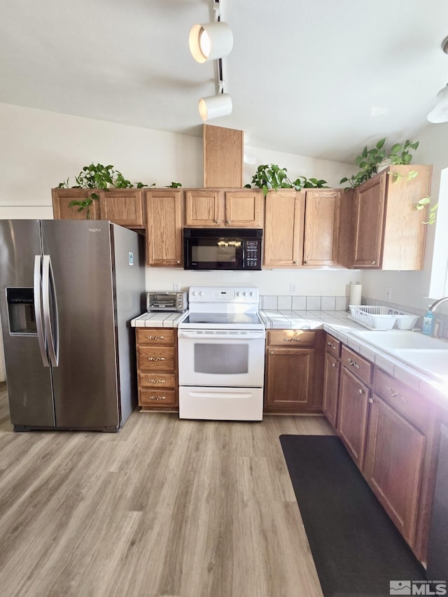 961 Ruddy Ct, Sparks, NV 89441 - kitchen featuring black microwave, electric stove, stainless steel refrigerator with ice dispenser, tile countertops, and light wood-style flooring