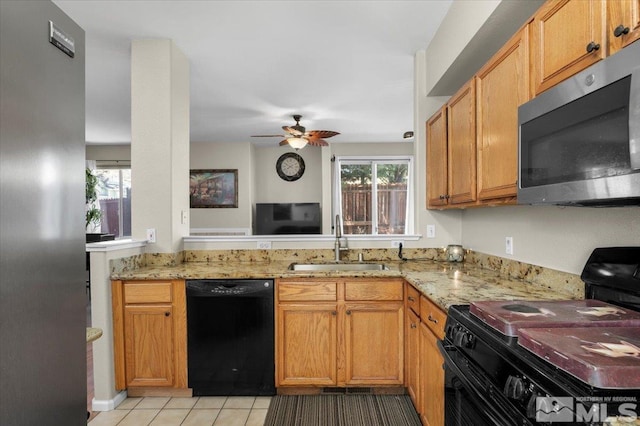 kitchen with black appliances, a sink, light stone countertops, and ceiling fan