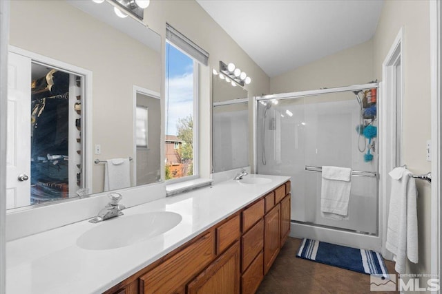 full bathroom featuring a shower stall, double vanity, tile patterned floors, and vaulted ceiling