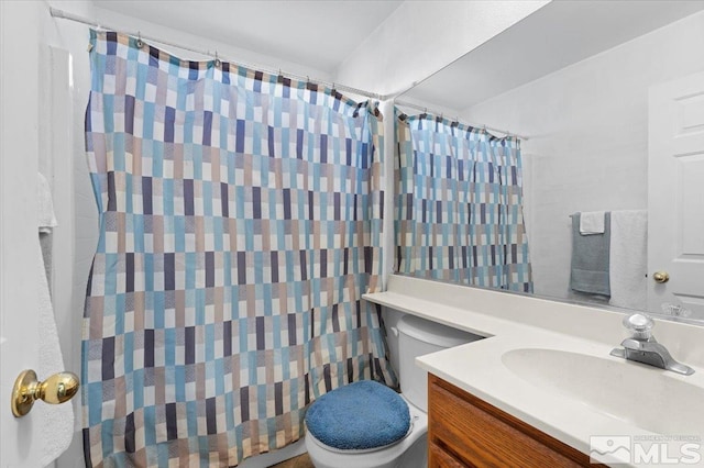 bathroom with toilet, vanity, and curtained shower