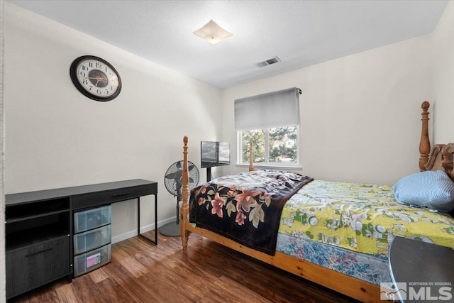 bedroom with wood finished floors and baseboards