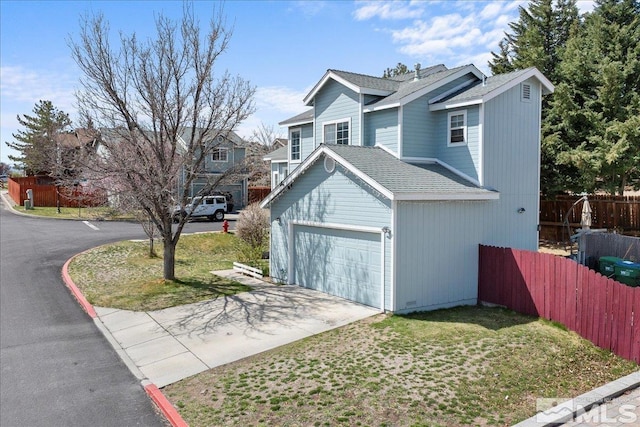 view of front of house featuring an attached garage, concrete driveway, and roof with shingles