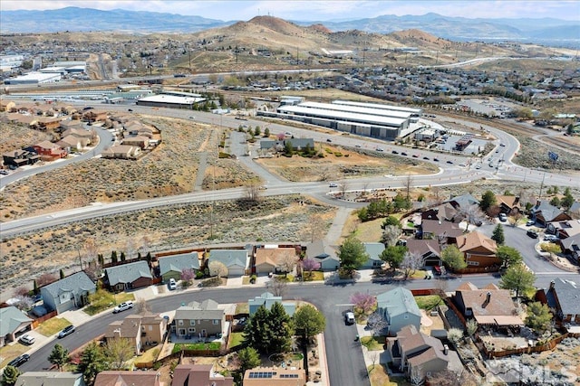 aerial view of property's location featuring a mountainous background and nearby suburban area