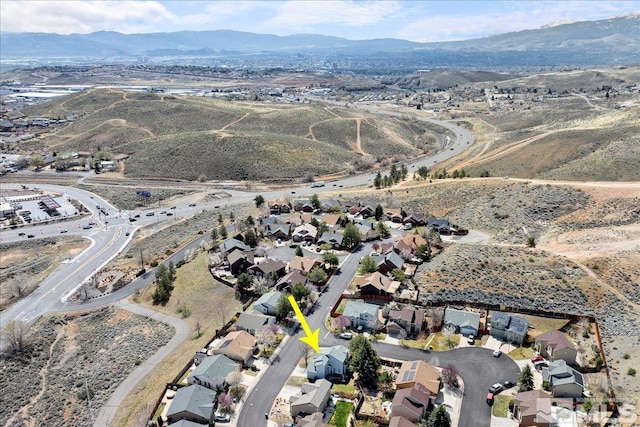 aerial view of property's location with a mountain backdrop and nearby suburban area