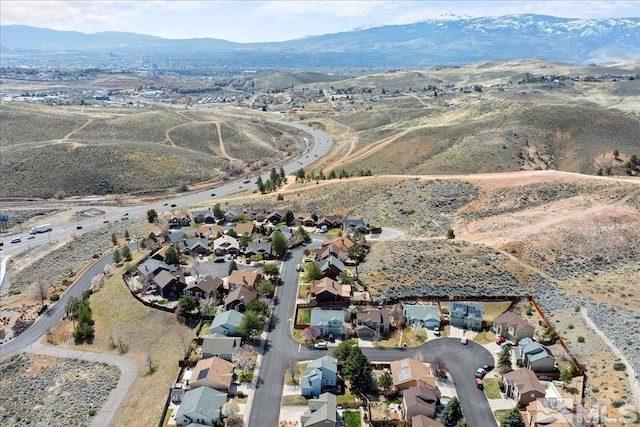aerial overview of property's location with a mountain backdrop and nearby suburban area