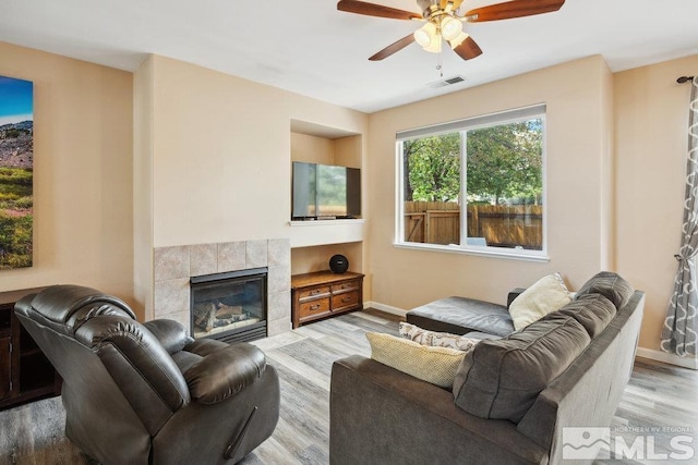 2190 Canyon Mesa Ct, Reno, NV 89523 - living room featuring a ceiling fan, a tiled fireplace, wood finished floors, and baseboards