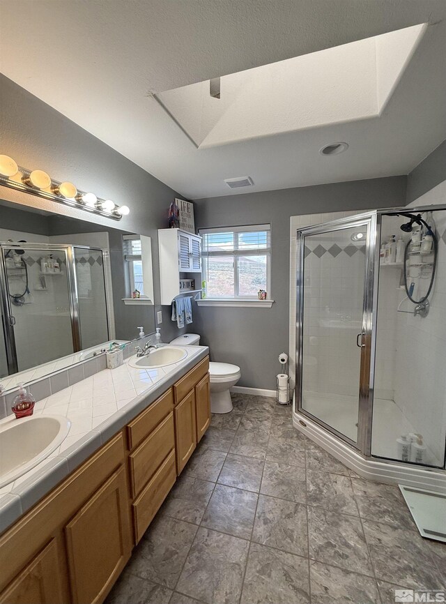 660 Castle Way, Winnemucca, NV 89445 - full bathroom featuring double vanity, a stall shower, toilet, and baseboards