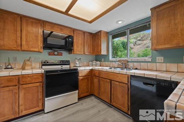 1940 Peavine Rd, Reno, NV 89503 - kitchen featuring black appliances, a sink, tile countertops, light wood-type flooring, and brown cabinets