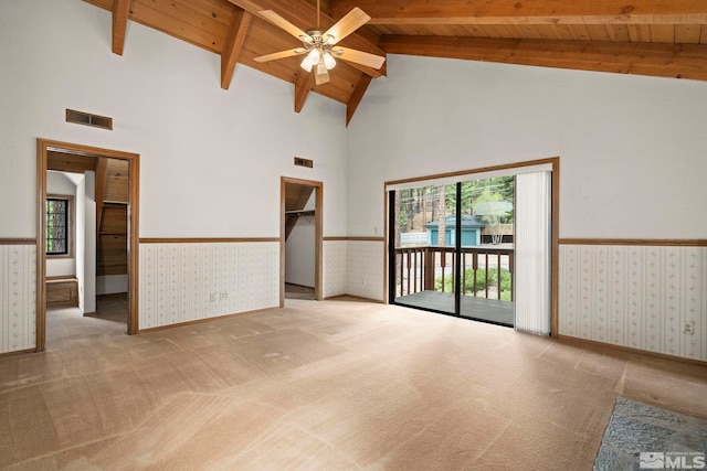 carpeted spare room with wainscoting, wallpapered walls, wooden ceiling, high vaulted ceiling, and a ceiling fan