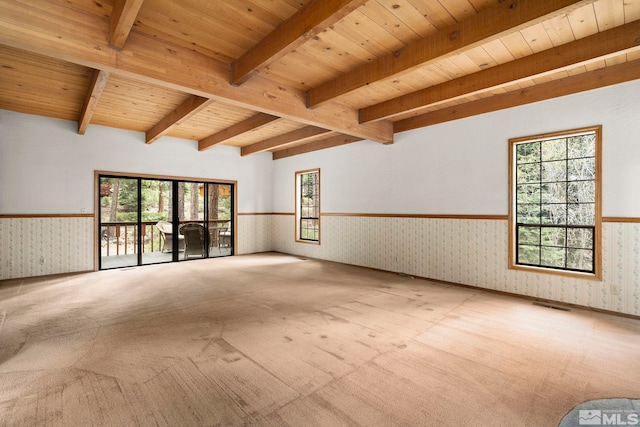 spare room featuring wallpapered walls, wainscoting, carpet flooring, wood ceiling, and healthy amount of natural light