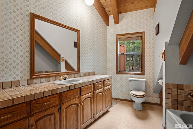 full bath with beamed ceiling, toilet, wallpapered walls, vanity, and a bath