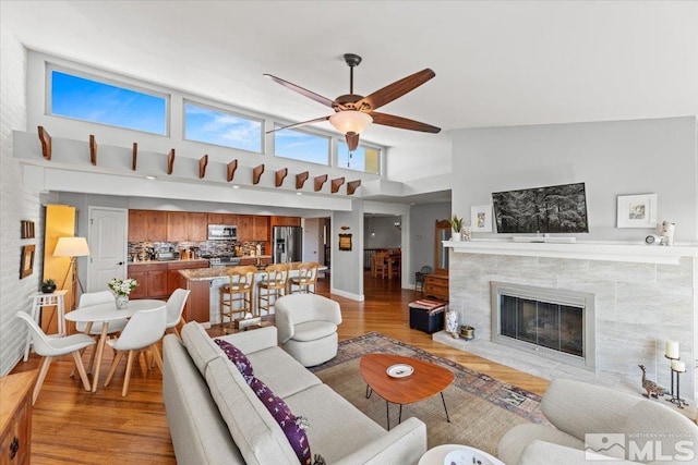 3425 Skyline Blvd, Reno, NV 89509 - living area featuring a ceiling fan, light wood-style flooring, a high ceiling, and a high end fireplace