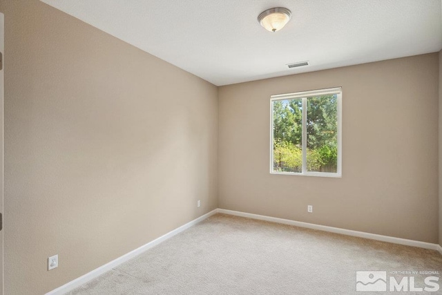spare room featuring baseboards and light colored carpet
