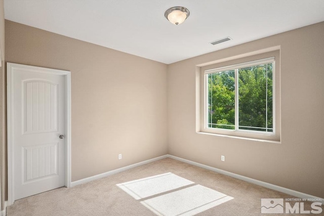 carpeted empty room featuring baseboards