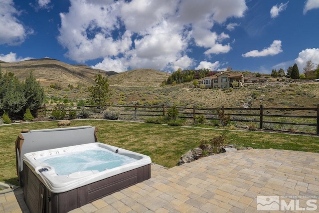 view of patio / terrace with a hot tub and a mountain view