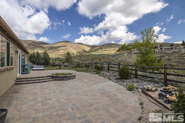 view of patio featuring a mountain view and a fenced backyard