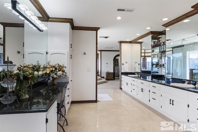 bathroom with crown molding, double vanity, recessed lighting, and baseboards