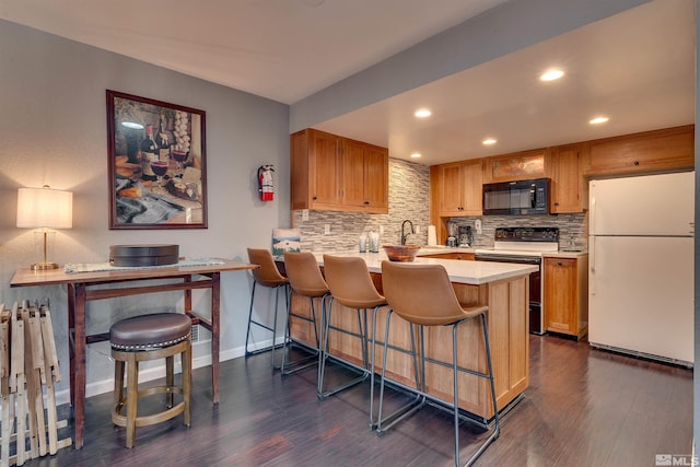 kitchen featuring freestanding refrigerator, range with electric cooktop, black microwave, recessed lighting, and backsplash