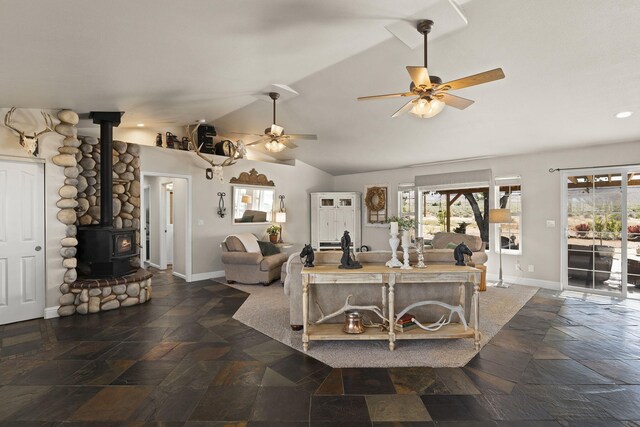 4800 Amy Rd, Reno, NV 89510 - living area featuring a wood stove, stone tile floors, vaulted ceiling, ceiling fan, and baseboards