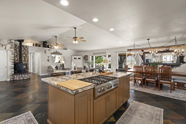 4800 Amy Rd, Reno, NV 89510 - kitchen featuring open floor plan, light countertops, a kitchen island, a wood stove, and stainless steel gas stovetop