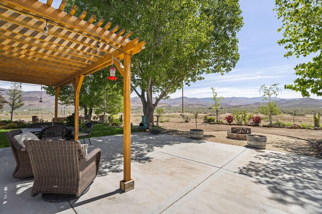 4800 Amy Rd, Reno, NV 89510 - view of patio / terrace with a mountain view, a pergola, outdoor dining area, and a fire pit