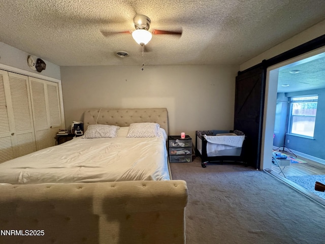 50 Bellevue Ave, Winnemucca, NV 89445 - carpeted bedroom featuring a barn door, a closet, a textured ceiling, and ceiling fan