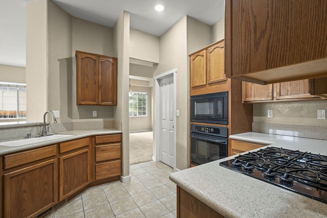 1196 Turnberry Dr, Sparks, NV 89436 - kitchen featuring black appliances, a sink, light tile patterned floors, light countertops, and brown cabinetry