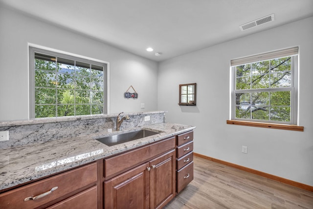 3150 Kings Canyon Rd, Carson City, NV 89703 - kitchen featuring a sink, light wood-style flooring, light stone countertops, baseboards, and brown cabinetry