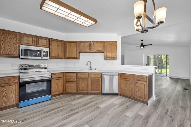 185 Windtree Cir, Carson City, NV 89701 - kitchen featuring appliances with stainless steel finishes, a sink, brown cabinetry, light wood-type flooring, and light countertops