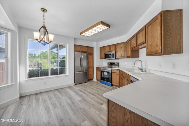 185 Windtree Cir, Carson City, NV 89701 - kitchen with appliances with stainless steel finishes, brown cabinets, a sink, and a chandelier