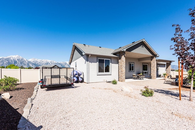 1023 Sun Crest Ct, Gardnerville, NV 89460 - back of house with stucco siding, a mountain view, fence, and a patio
