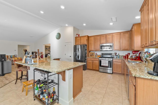 1390 Tule Peak Cir, Carson City, NV 89701 - kitchen with stainless steel appliances, a sink, vaulted ceiling, a kitchen bar, and light tile patterned flooring
