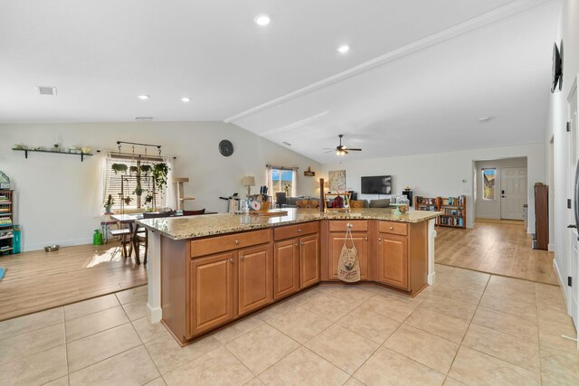 1390 Tule Peak Cir, Carson City, NV 89701 - kitchen with healthy amount of natural light, light tile patterned flooring, a ceiling fan, lofted ceiling, and light stone countertops