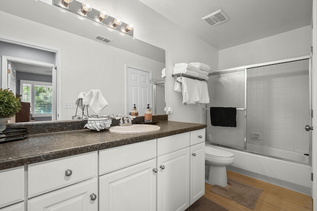 2107 G St, Sparks, NV 89431 - full bath with wood finished floors, toilet, vanity, and bath / shower combo with glass door