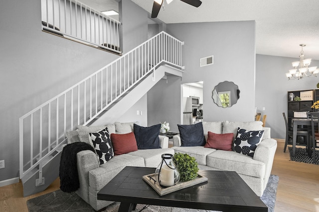 2107 G St, Sparks, NV 89431 - living room featuring stairs, light wood finished floors, a chandelier, a ceiling fan, and a high ceiling