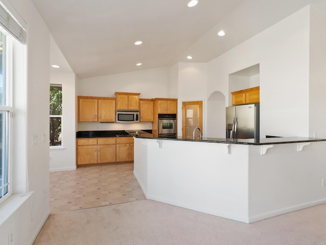 570 Buckskin Dr, Fernley, NV 89408 - kitchen featuring appliances with stainless steel finishes, light colored carpet, dark countertops, a breakfast bar, and recessed lighting