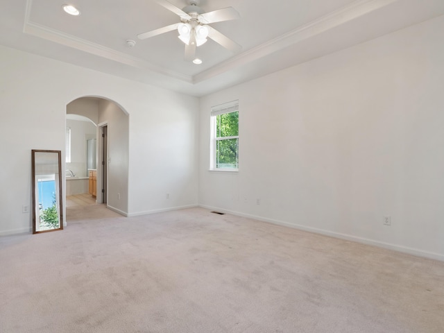 570 Buckskin Dr, Fernley, NV 89408 - unfurnished room with a raised ceiling, crown molding, arched walkways, ceiling fan, and light colored carpet