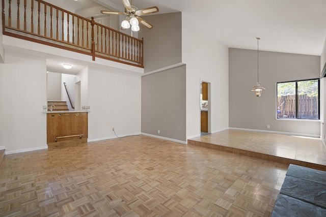 1043 Shenandoah Dr, Carson City, NV 89702 - unfurnished living room with high vaulted ceiling, baseboards, ceiling fan, and stairs