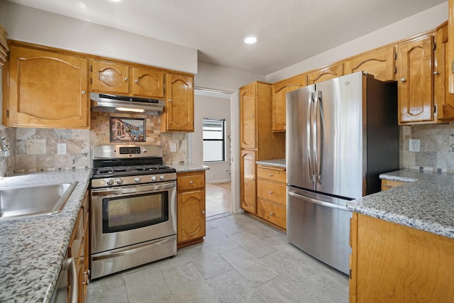 1043 Shenandoah Dr, Carson City, NV 89702 - kitchen with stainless steel appliances, under cabinet range hood, tasteful backsplash, a sink, and brown cabinets