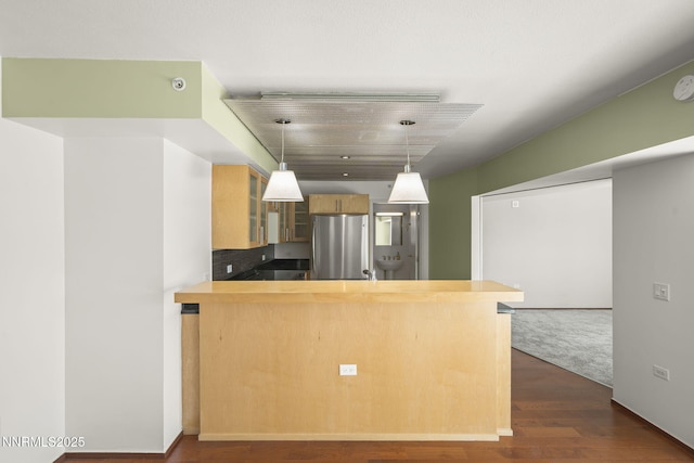255 N Sierra St Unit 1419, Reno, NV 89501 - kitchen featuring freestanding refrigerator, glass insert cabinets, a peninsula, dark wood-style floors, and decorative light fixtures