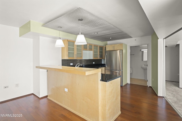 255 N Sierra St Unit 1419, Reno, NV 89501 - kitchen with freestanding refrigerator, a peninsula, glass insert cabinets, and dark wood finished floors