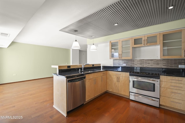 255 N Sierra St Unit 1419, Reno, NV 89501 - kitchen with appliances with stainless steel finishes, a peninsula, dark wood-style flooring, decorative backsplash, and glass insert cabinets