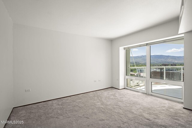 255 N Sierra St Unit 1419, Reno, NV 89501 - carpeted empty room featuring a mountain view and baseboards