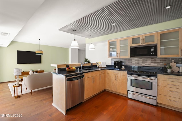 255 N Sierra St Unit 1419, Reno, NV 89501 - kitchen featuring appliances with stainless steel finishes, a peninsula, dark wood-style flooring, decorative backsplash, and dark countertops