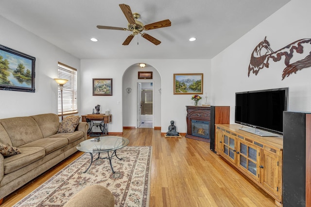 1634 Buzzys Ranch Rd, Carson City, NV 89701 - living room featuring arched walkways, a glass covered fireplace, ceiling fan, light wood-style floors, and recessed lighting