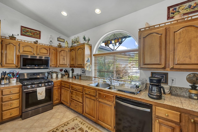 1634 Buzzys Ranch Rd, Carson City, NV 89701 - kitchen with stainless steel appliances, lofted ceiling, brown cabinets, light tile patterned floors, and recessed lighting