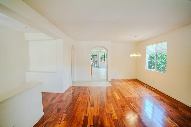2413 San Remo Dr, Sparks, NV 89434 - spare room featuring wood finished floors, arched walkways, and plenty of natural light