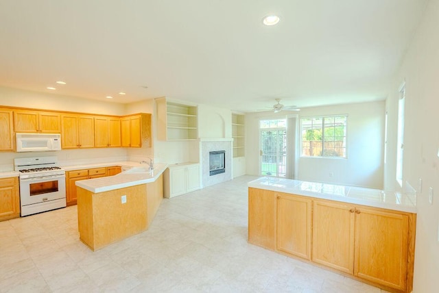 2413 San Remo Dr, Sparks, NV 89434 - kitchen featuring white appliances, a peninsula, a glass covered fireplace, light countertops, and recessed lighting