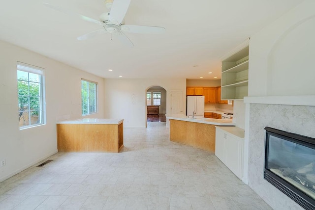 2413 San Remo Dr, Sparks, NV 89434 - kitchen featuring open shelves, freestanding refrigerator, a peninsula, arched walkways, and baseboards