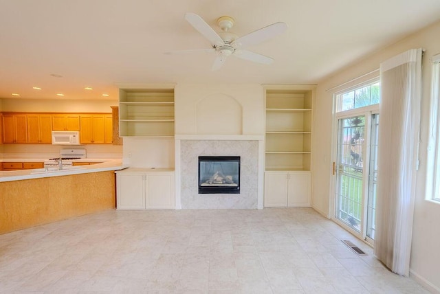 2413 San Remo Dr, Sparks, NV 89434 - unfurnished living room featuring a glass covered fireplace, built in shelves, recessed lighting, and ceiling fan